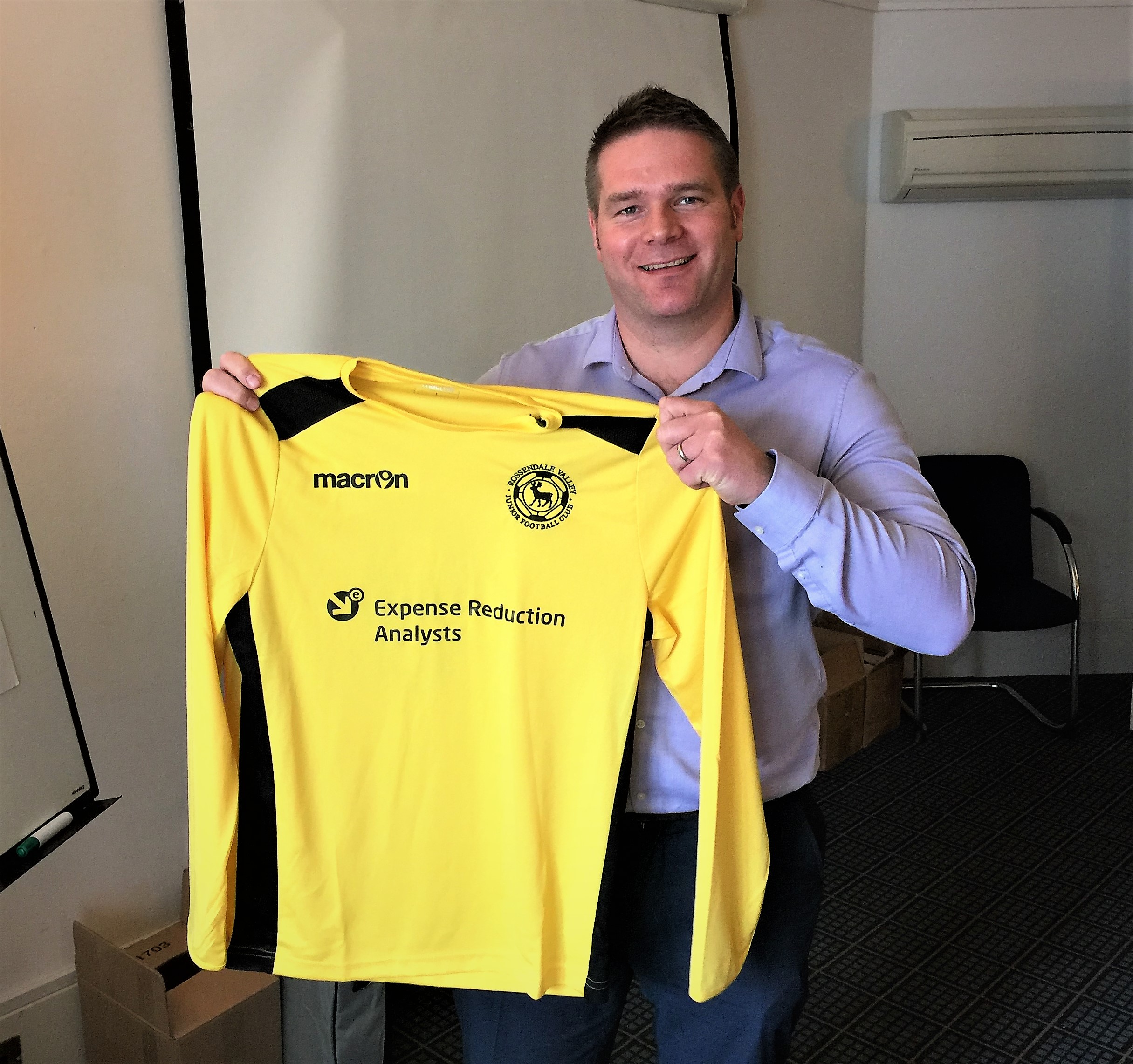 Iain Clement holding the sponsored football shirt